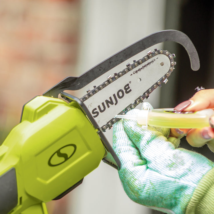 Oil being applied to Sun Joe Cordless Hand Chainsaw