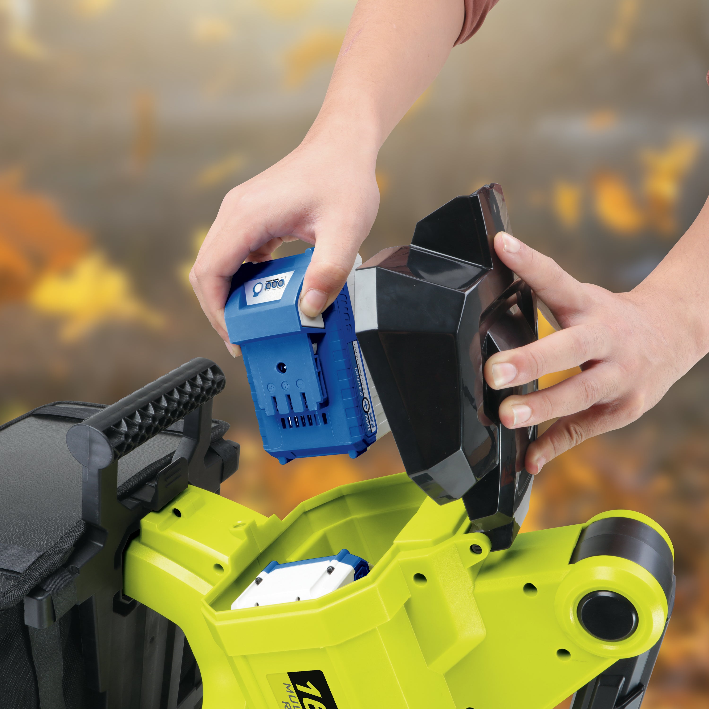 Person inserting a 4.0-Ah lithium-ion battery into the Sun Joe 48-volt Cordless Outdoor Garden Vacuum/Mulcher Kit.