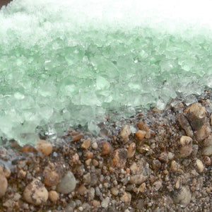 Close-up of the Keep It Green ice melt melting snow on the ground.