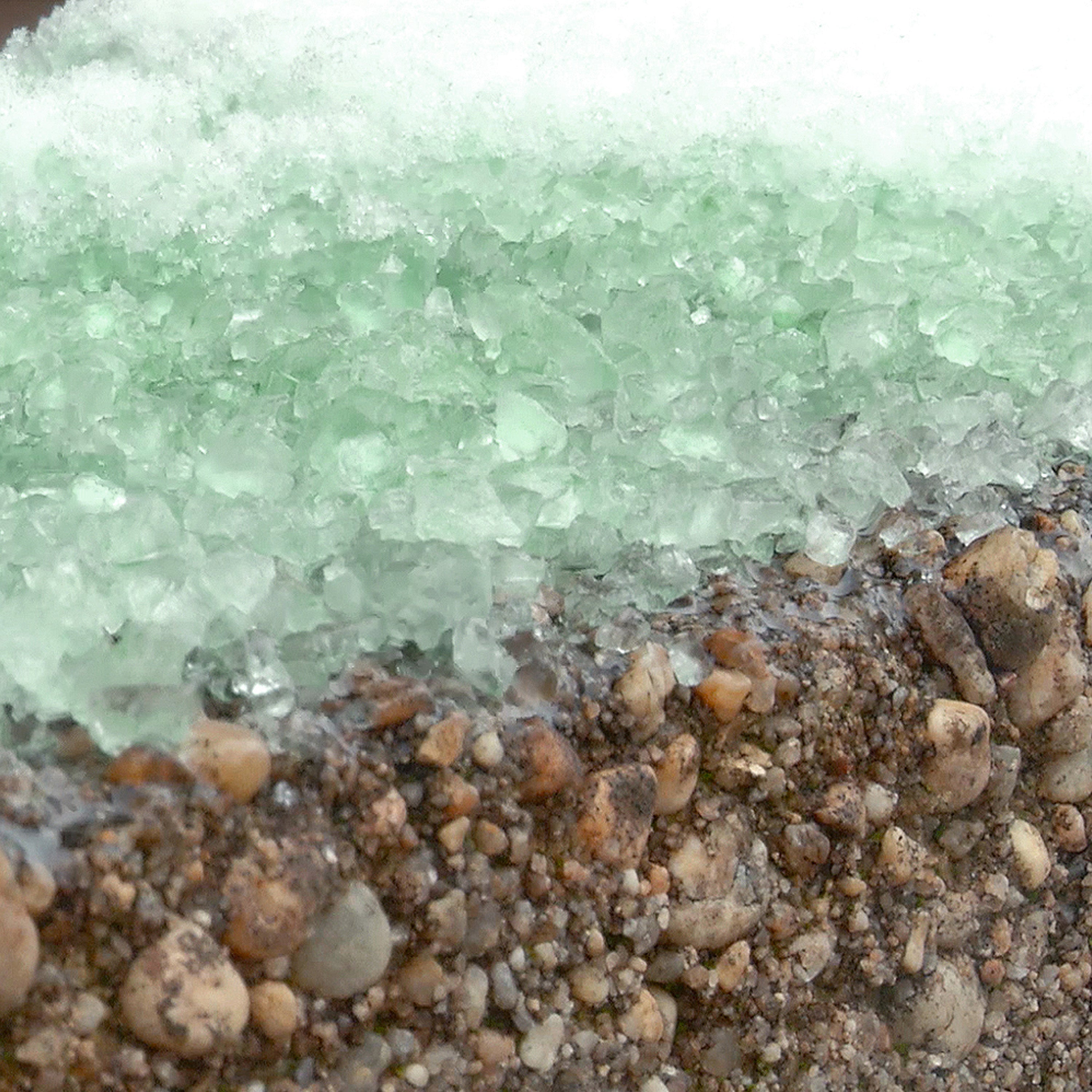 Close-up of the Keep It Green ice melt melting snow on the ground.