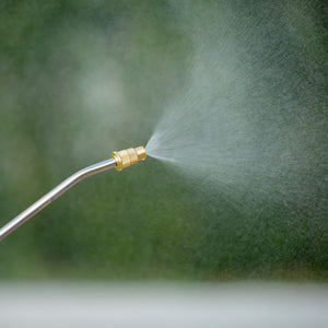 The spray wand for the Sun Joe 24-volt cordless Multi-Purpose Chemical Sprayer Kit spraying liquid into the air.