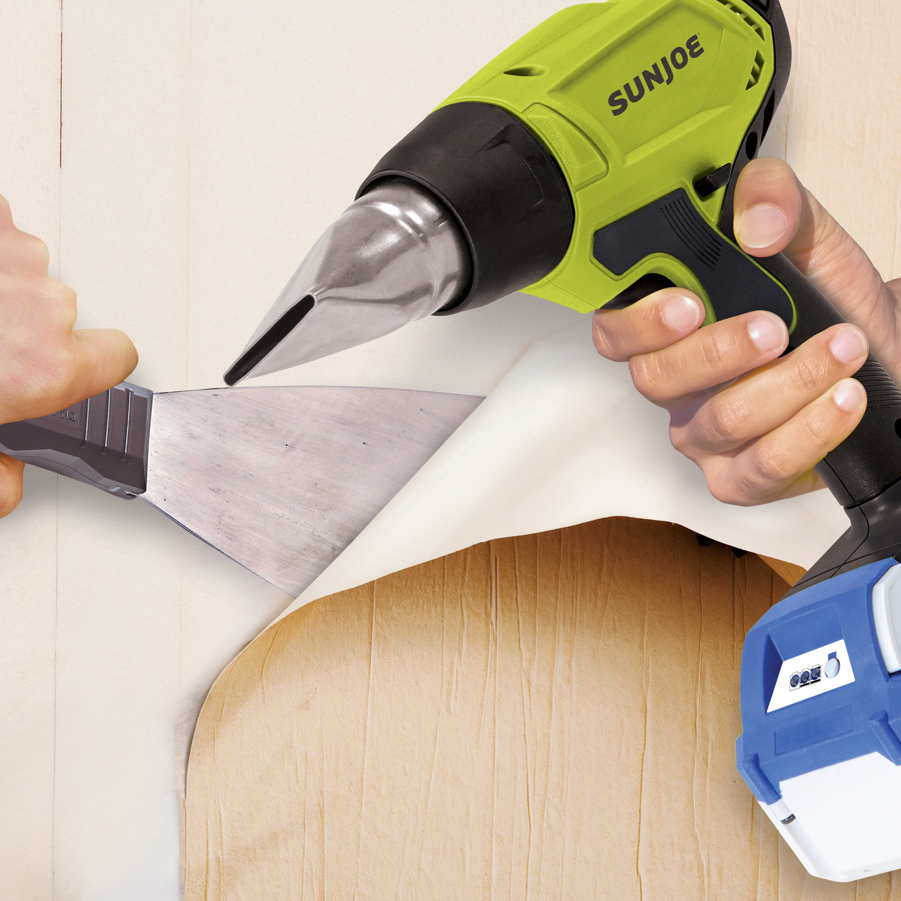 Person using the Sun Joe 24-volt cordless Heat Gun to peel wallpaper off a wall.