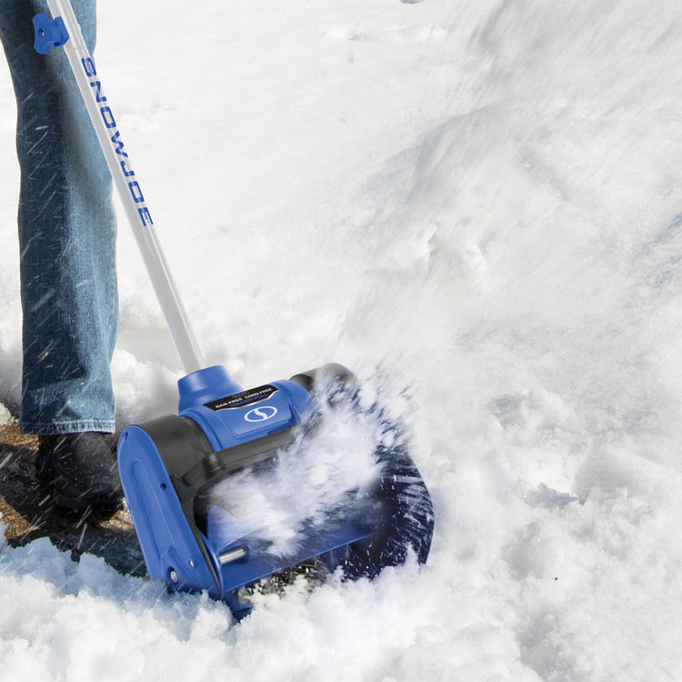 Person using the Snow Joe 24-volt cordless 12-inch snow shovel kit to clear away snow.