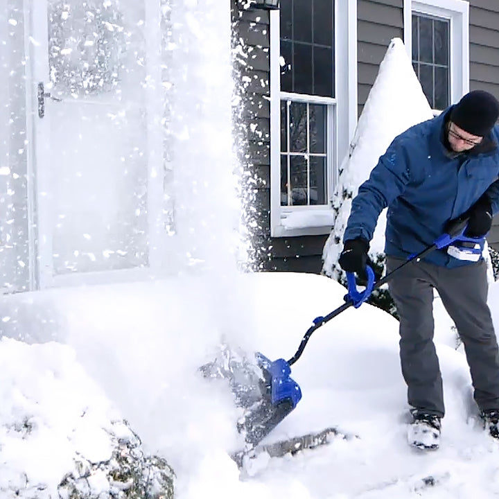 Man using the Snow Joe 24-volt cordless 13-inch snow shovel kit to clear snow off front steps.