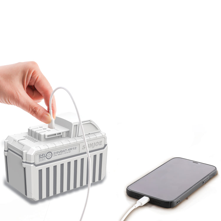 Snow Joe and Sun Joe 24-volt 12-Ah lithium-ion battery being used to charge a cell phone with the USB port.