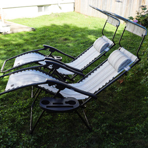 Set of 2 26-inch casual stripe gravity free chairs reclined on a lawn.