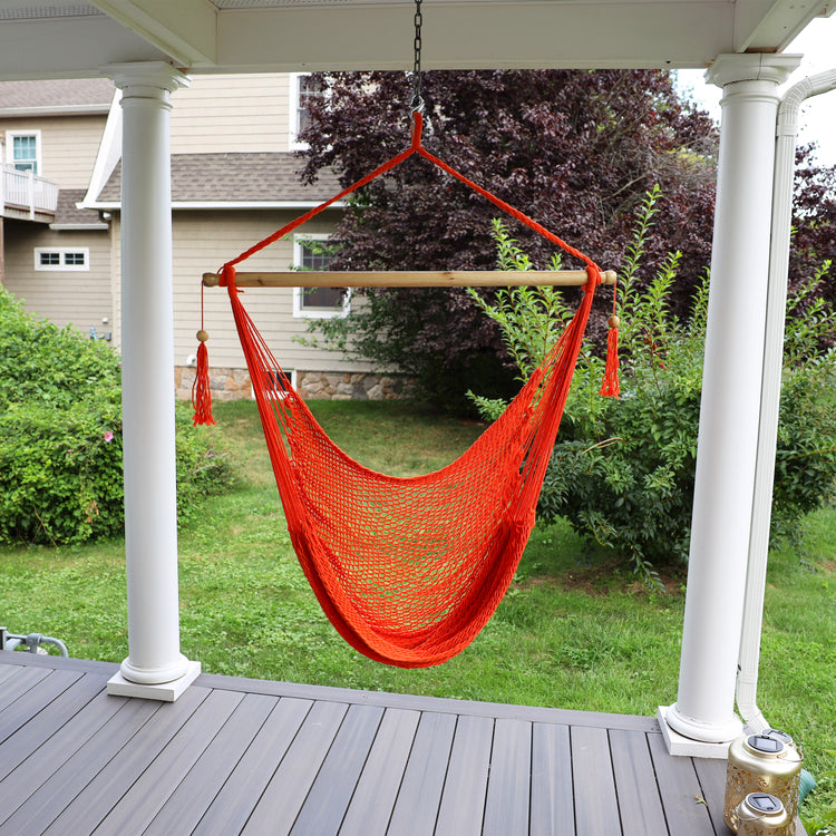 Bliss Hammocks 40-inch Orange Island Rope Hammock Chair hanging on a front porch.