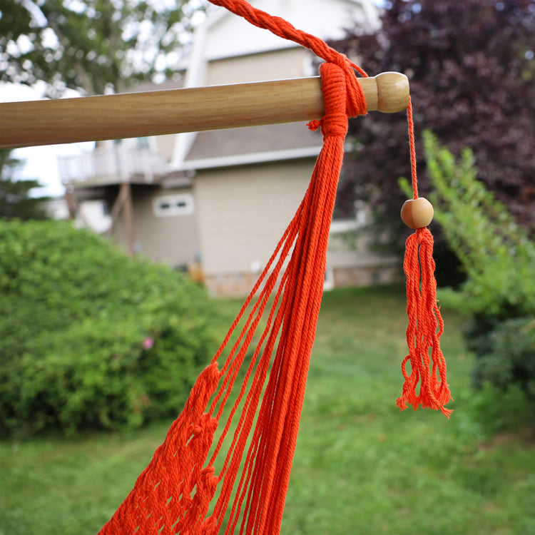 Close-up of the spreader bar and tassel on the Bliss Hammocks 40-inch Orange Island Rope Hammock Chair.