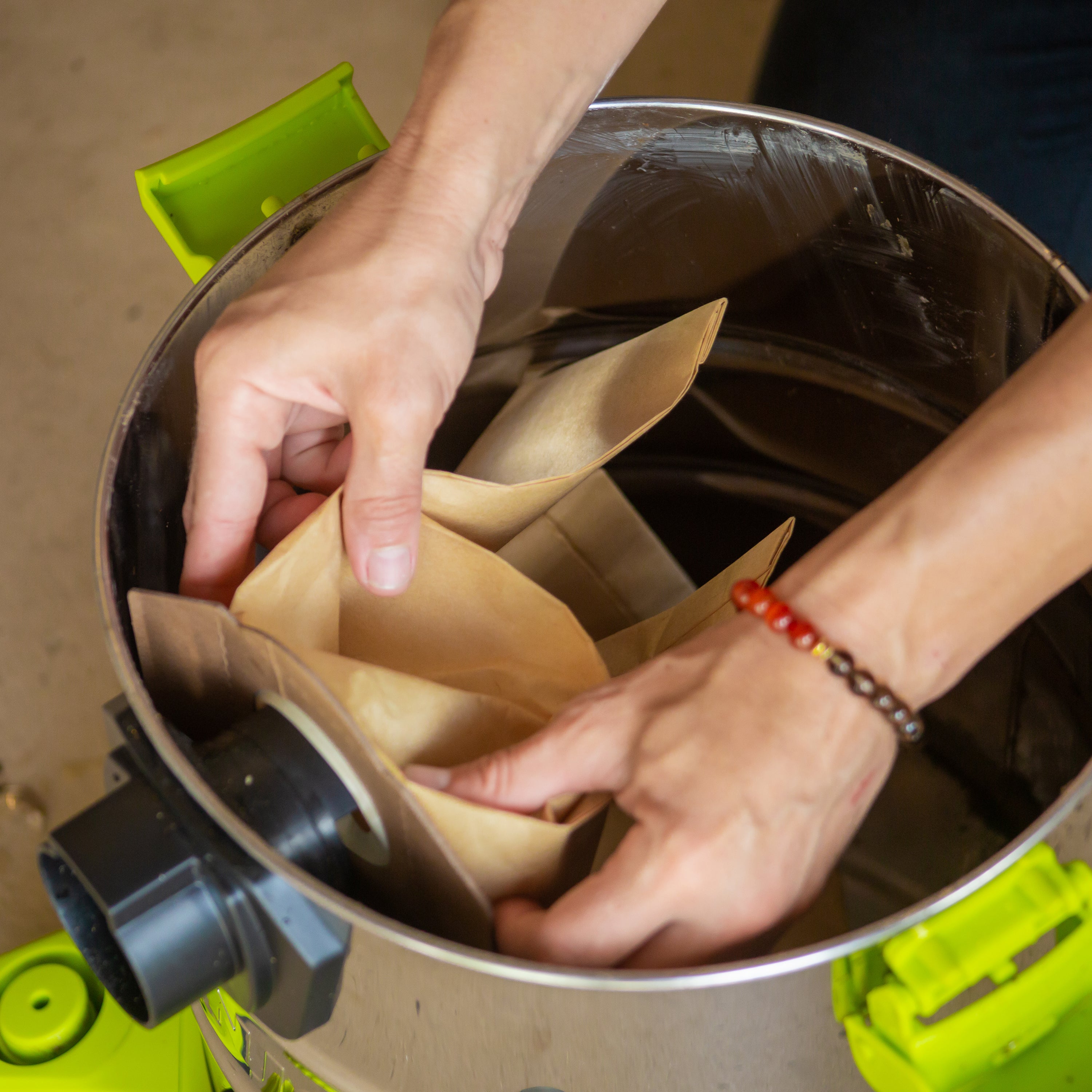 Person replacing the bag for the Sun Joe 24-volt Cordless Portable Stainless Steel Wet/Dry Vacuum Kit.