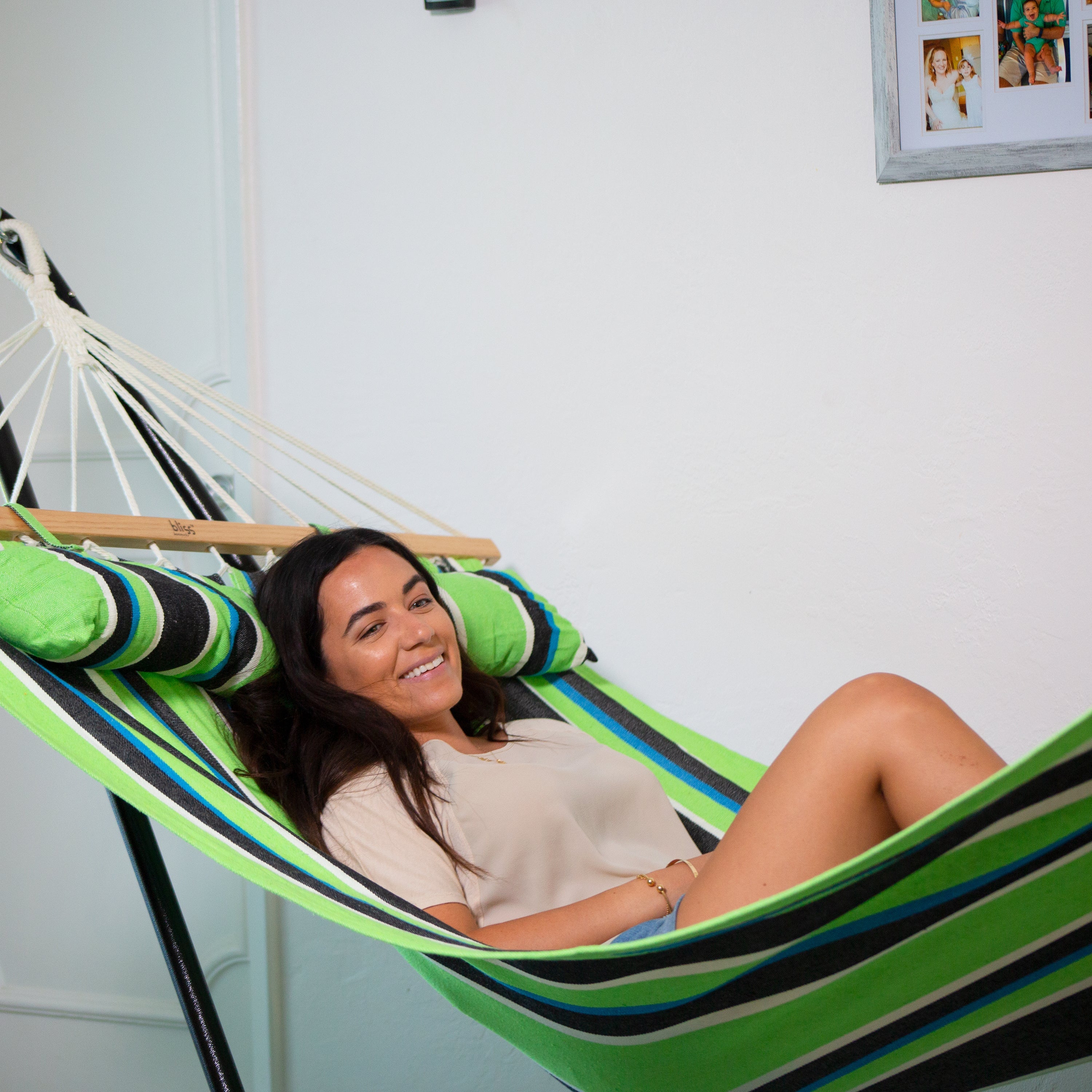 Woman laying indoors on the Bliss Hammocks 48-inch Wide Mediterranean Stripe Caribbean Hammock.