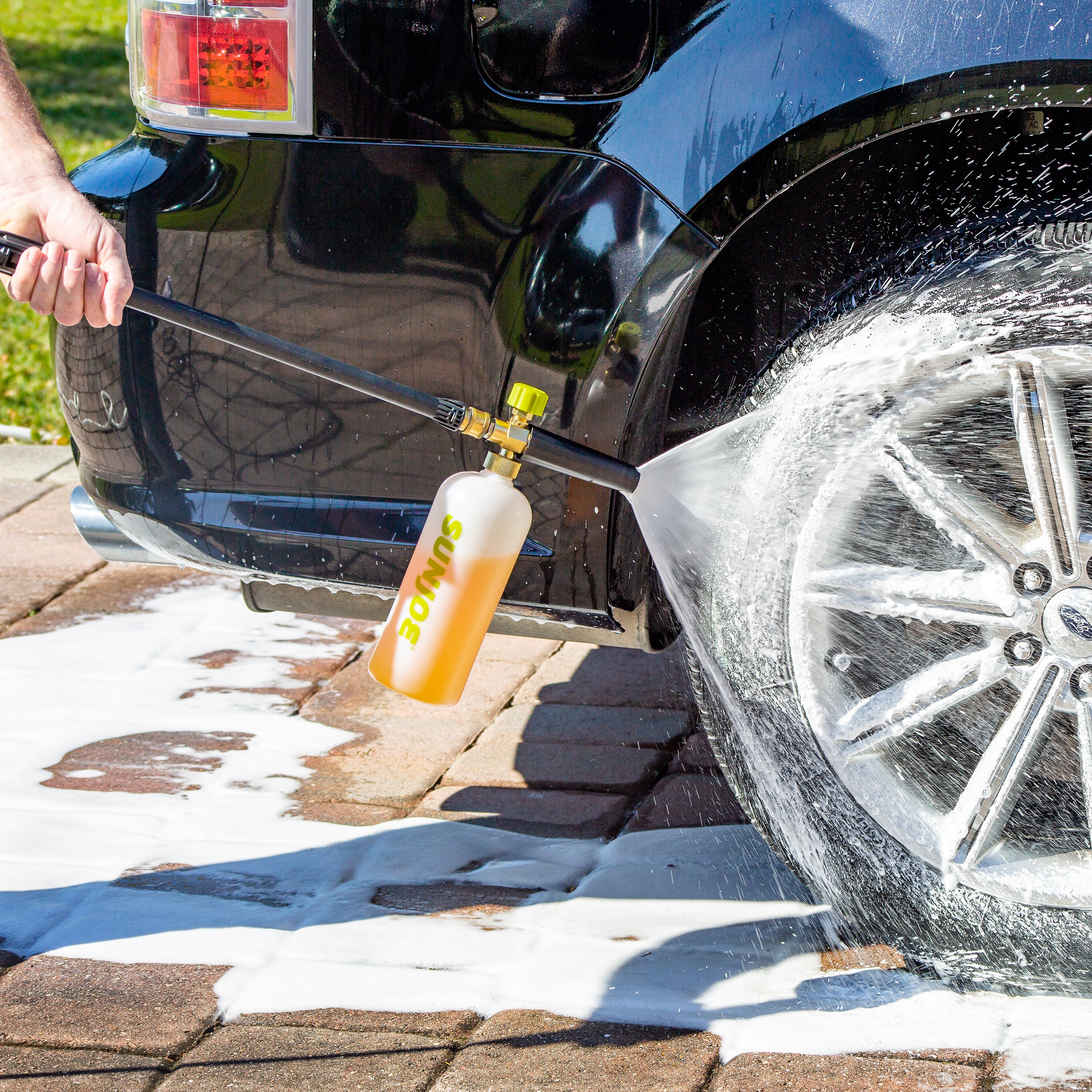 Sun Joe 34-ounce Foam Cannon for SPX Series Electric Pressure Washers being used to clean a car tire.