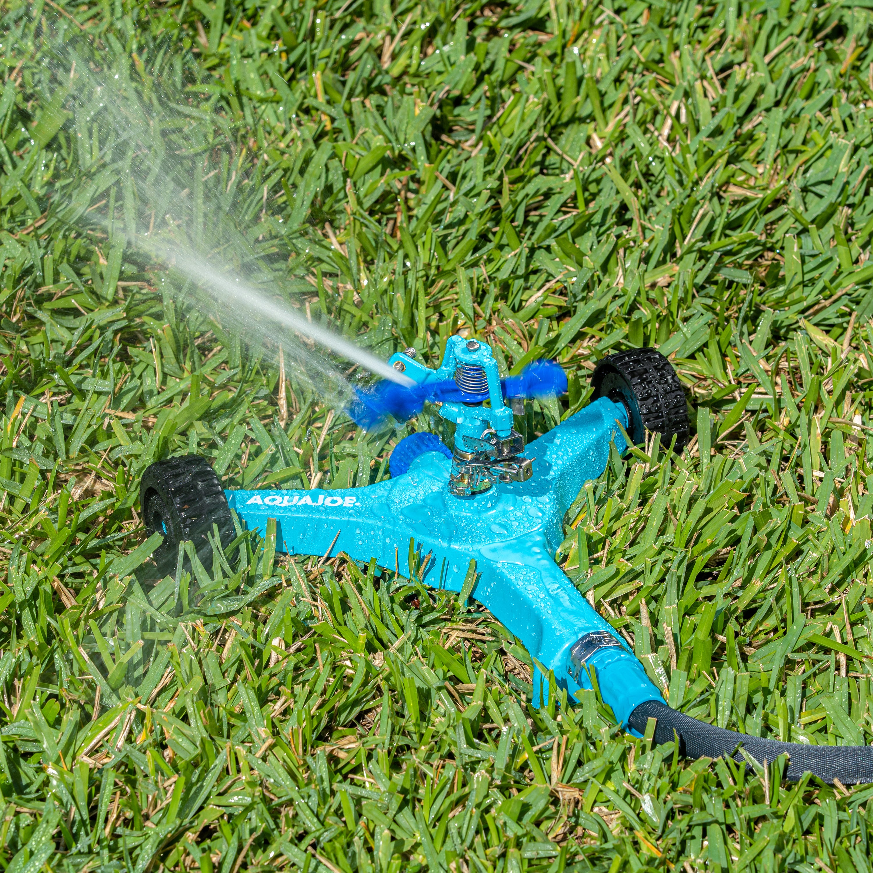 Aqua Joe 10-inch wheeled base Indestructible Zinc Impulse 360 Degree Sprinkler watering a lawn.