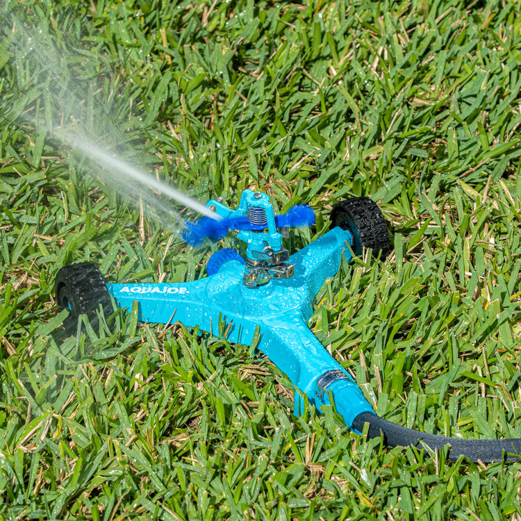 Aqua Joe 6-inch wheeled base Indestructible Zinc Impulse 360 Degree Sprinkler watering a lawn.