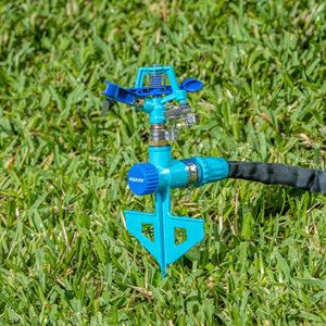 Aqua Joe Indestructible Zinc Impulse 360 Degree Sprinkler staked in the ground connected to a hose.