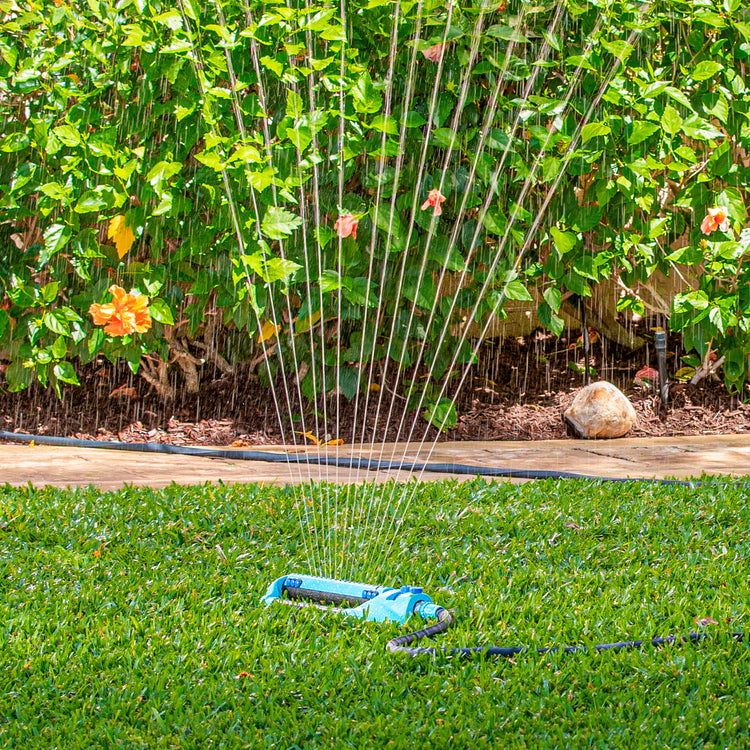 Aqua Joe 20-nozzle Indestructible Metal Base Oscillating Sprinkler watering a lawn.