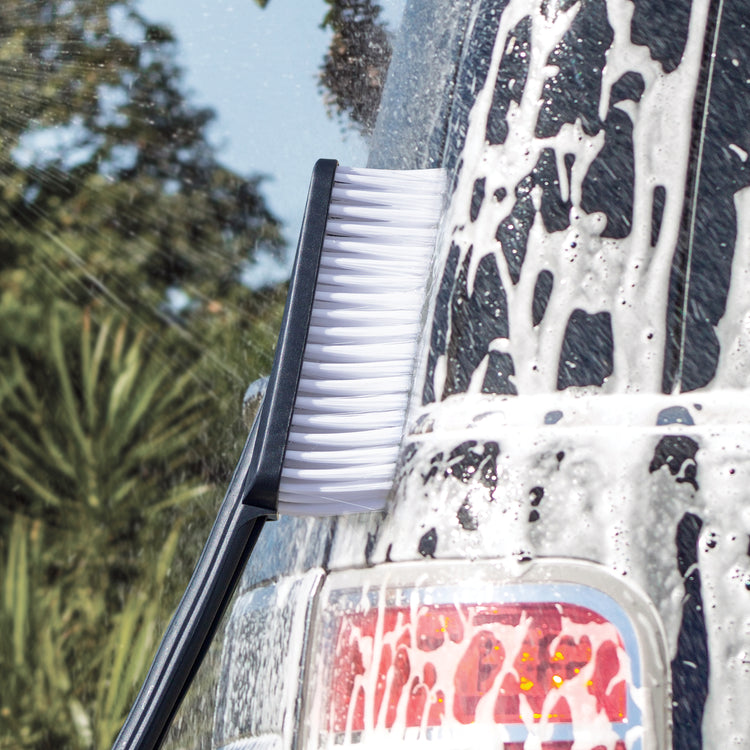 Bristle brush scrubbing a car.