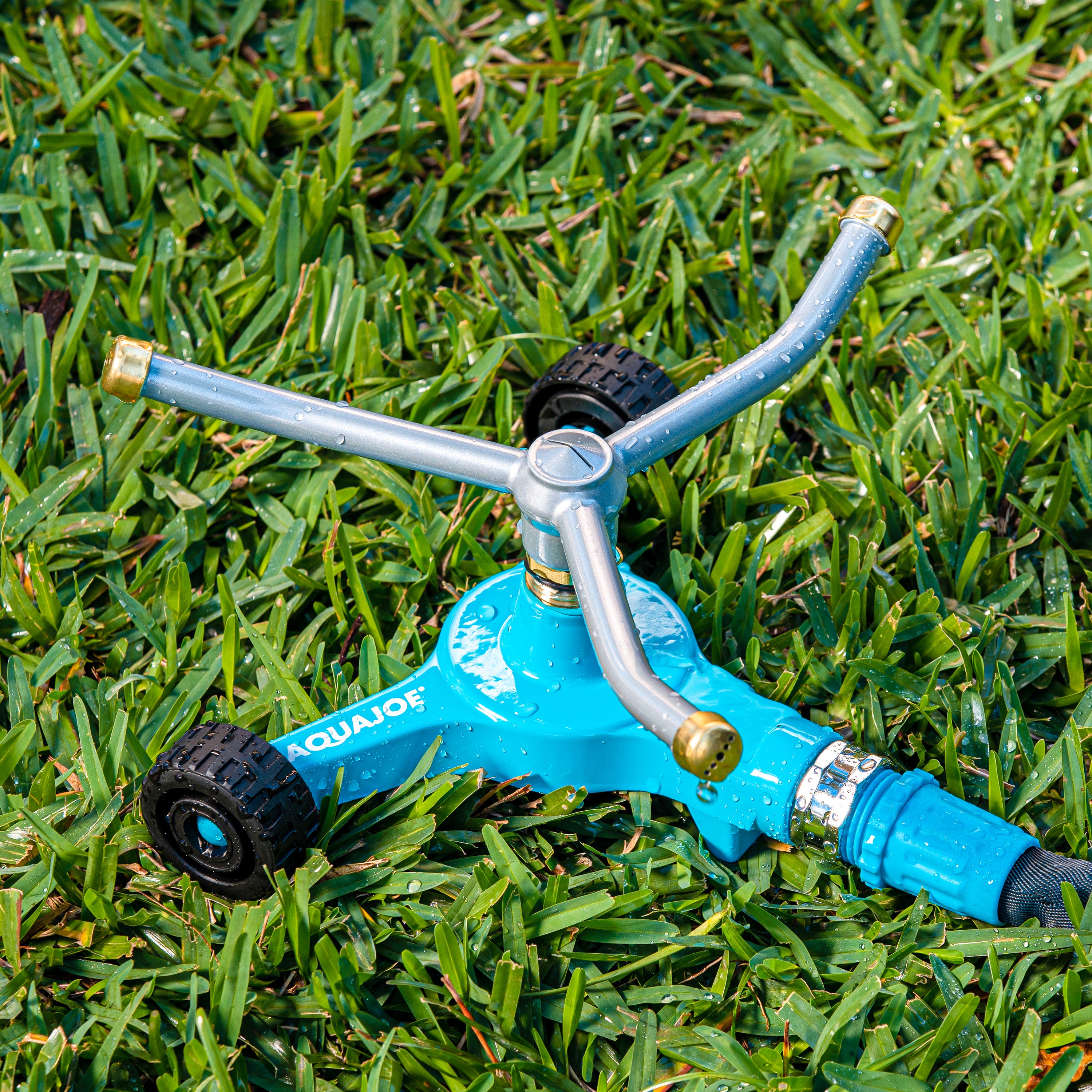 Aqua Joe Indestructible 3-Arm Zinc Rotary 360 Degree Sprinkler with wheeled base sitting in grass.