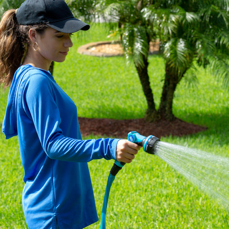 Woman using the Aqua Joe Heavy Duty Indestructible Metal Multi Function Adjustable Hose Nozzle to water.