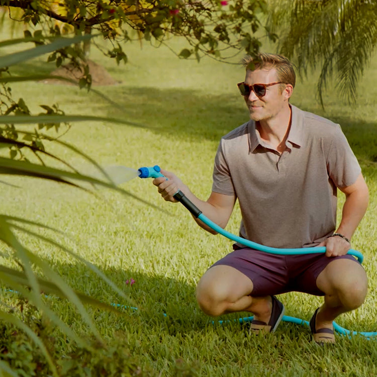 Man Using Aqua Joe Hybridflex Hose to water plant