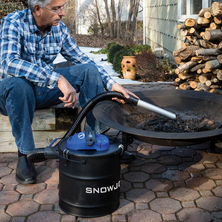 Snow Joe 4.8-gallon Ash Vacuum being used to suck up ash from a fire pit.