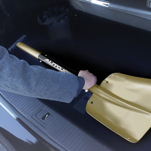 Person storing their utility shovel in the trunk of a car.