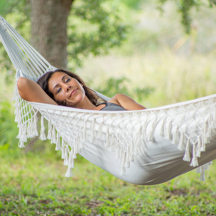 Woman relaxing outside in the Bliss Hammocks 40" Wide Hammock in a Bag with Fringe.