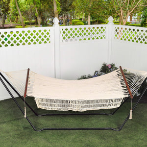 48-inch rope hammock hanging from a stand in a back yard.