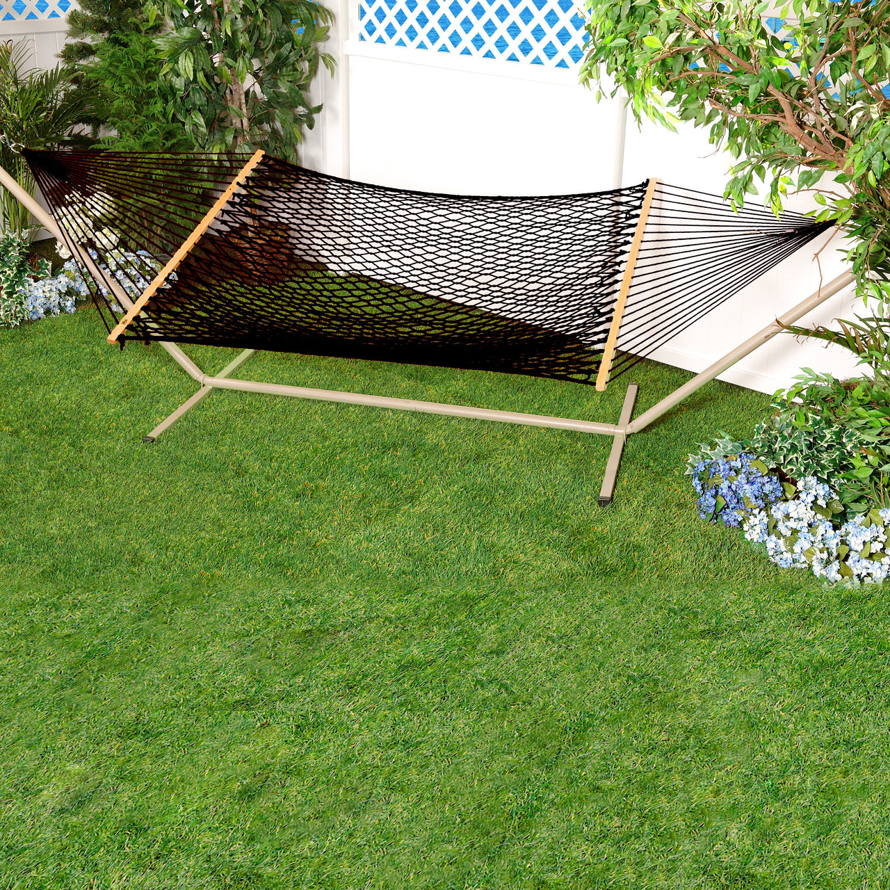 Bliss Hammocks 60-inch Wide Black Cotton Rope Hammock secured to a stand in a backyard.
