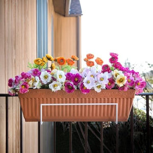 Sun Joe Deco Joe Flower Box Holder in White holding flowers on a railing.