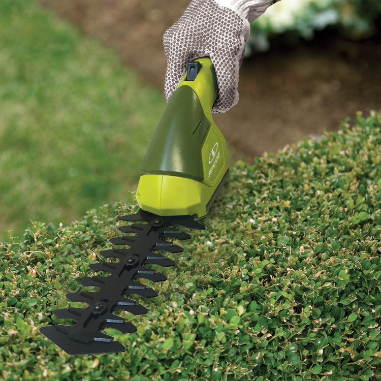 Sun Joe 7.2-volt Cordless Telescoping green Grass Shear and Hedge Trimmer being used without the pole to trim a hedge.