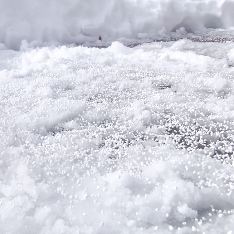 Snow Joe Pure Calcium Chloride Ice Melt Pellets being used on snow.