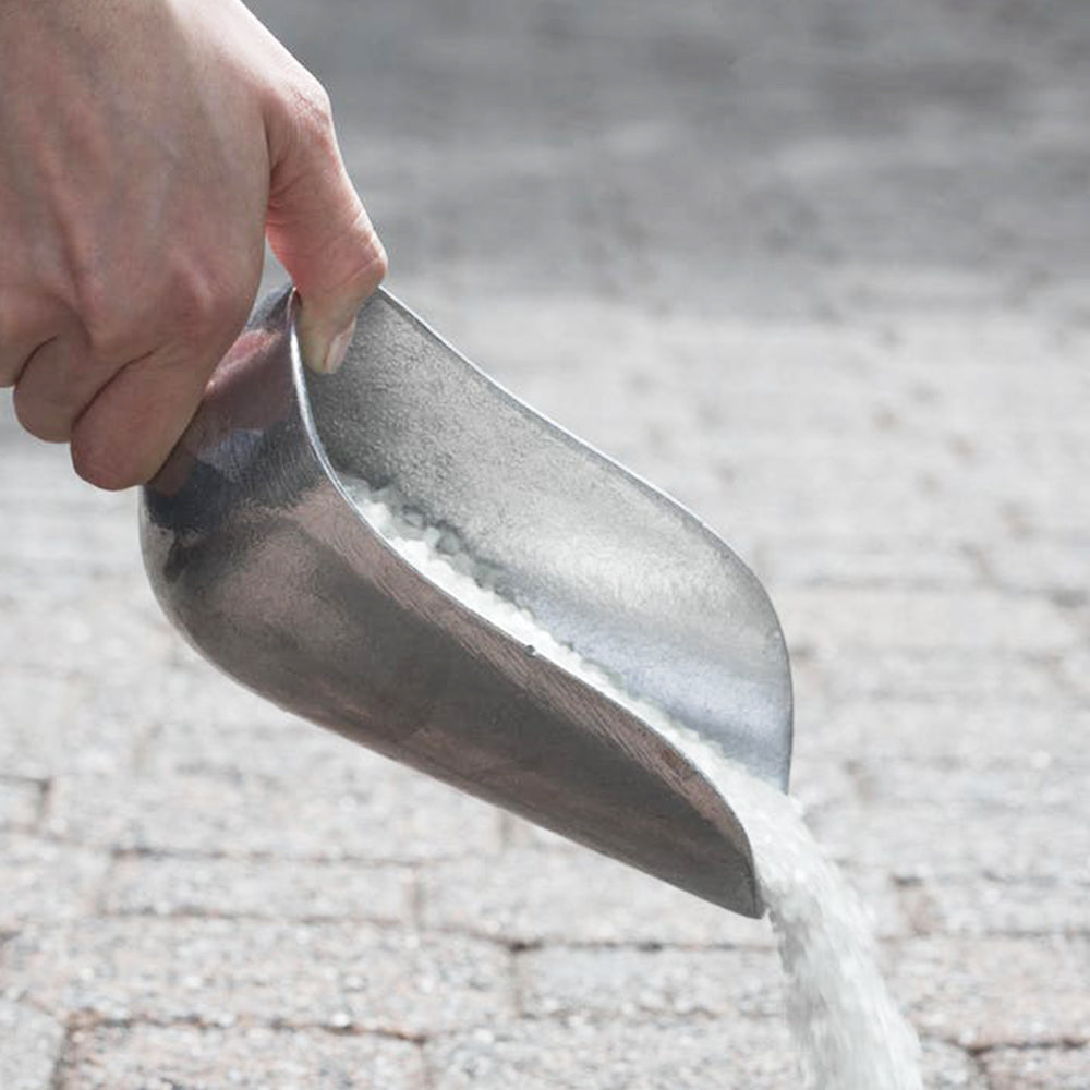 Snow Joe Calcium Chloride Ice Melt Blend being poured from the scooper.