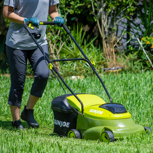 Sun Joe 28-volt 5-amp 14-inch Brushless Cordless Lawn Mower cutting a lawn.