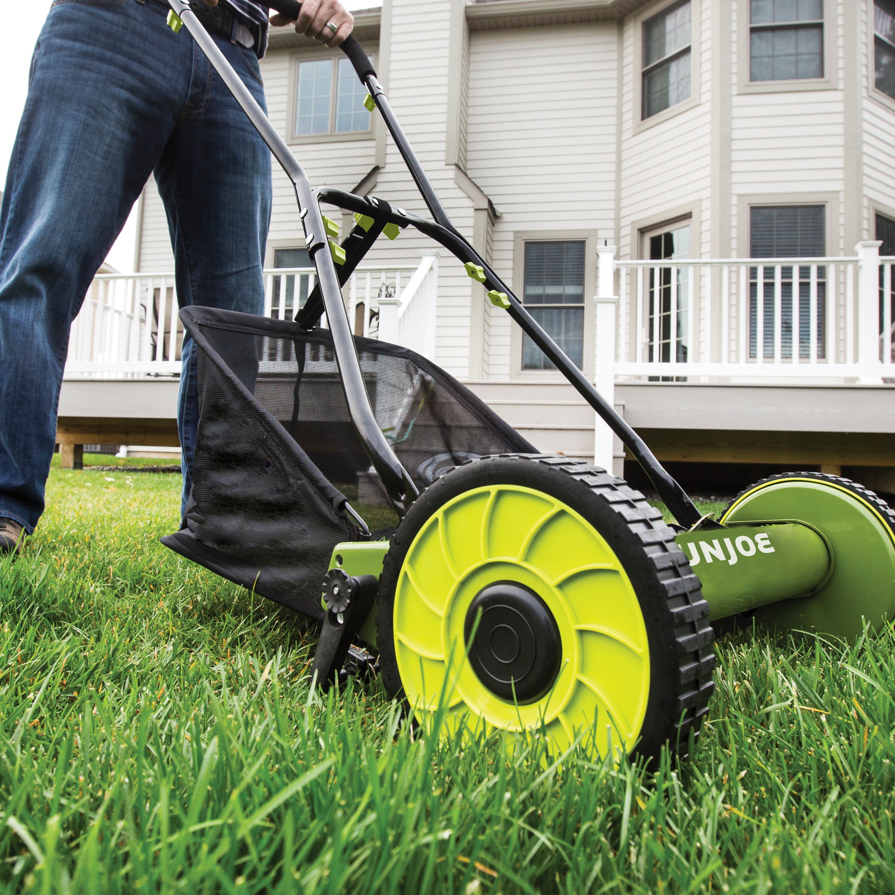 Sun Joe 16-inch Manual Reel Lawn Mower with grass catcher cutting grass.