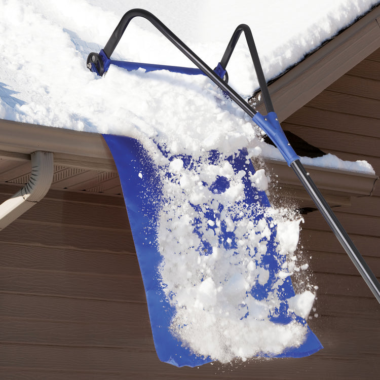 Snow Joe 28-foot snow removal roof rake being used on a roof with the snow falling down the debris slide.