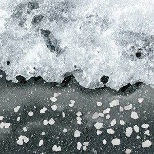 Rock salt ice melt melting ice on a driveway.