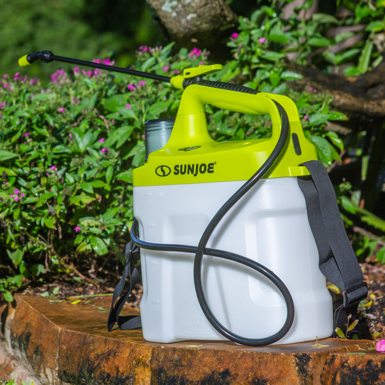 Sun Joe 4-volt 2-gallon Cordless All Purpose Chemical Sprayer sat next to a small garden.