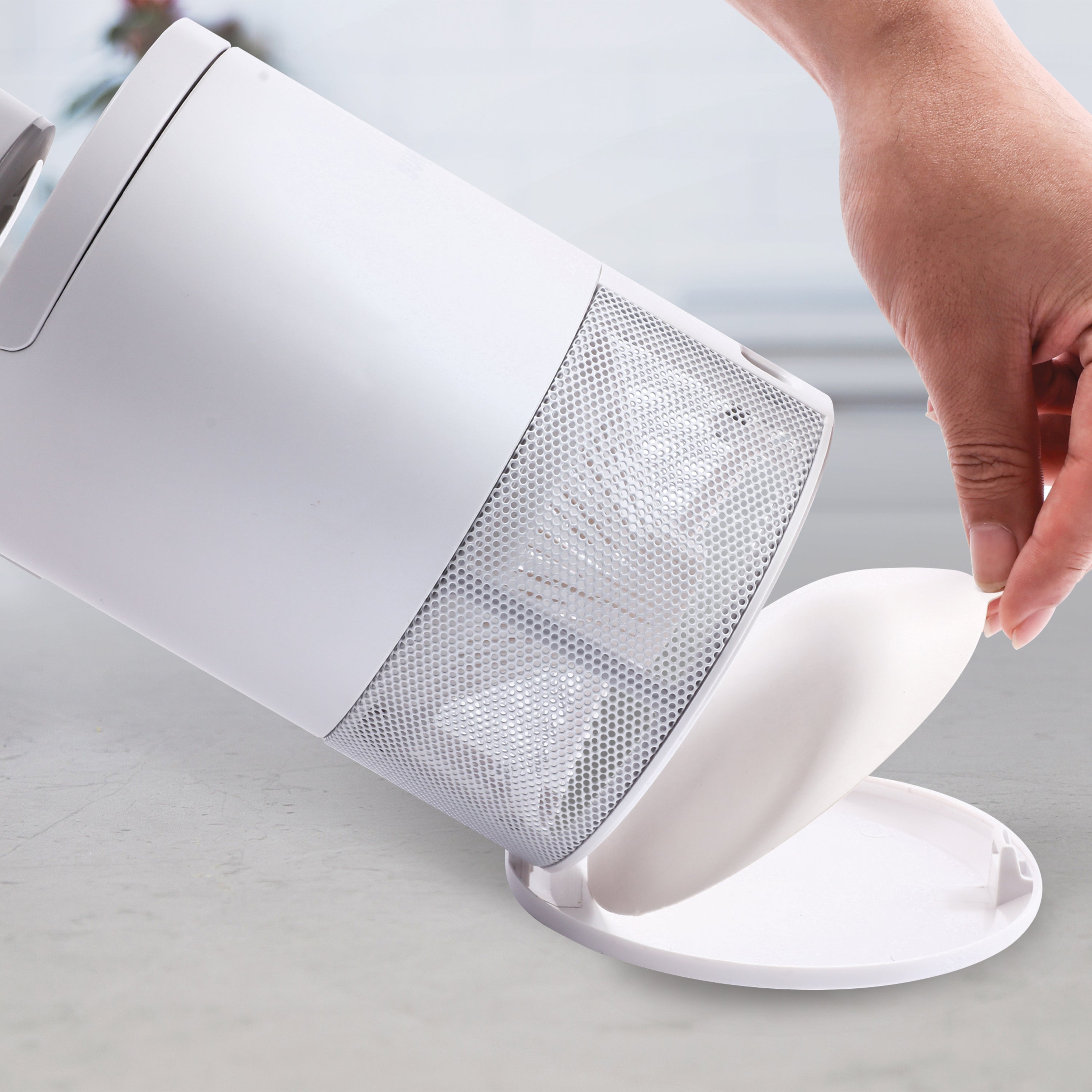 Person placing a new sticky trap into the tray on the bottom of the Sun Joe white non-toxic UV Indoor Insect Trap