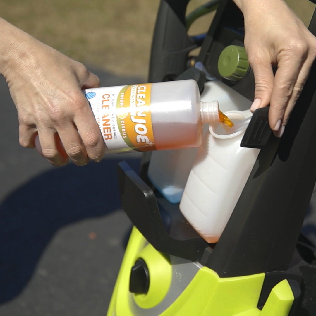 Person pouring the multi-surface cleaner into a pressure washer detergent tank.