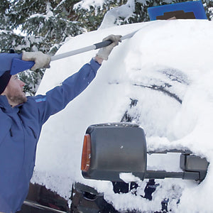 Snow Joe 19-inch 2-In-1 Telescoping Snow Broom and Ice Scraper being used to push snow off the top of a car.