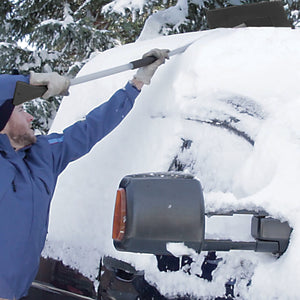 Snow Joe 19-inch 2-In-1 Telescoping black Snow Broom and Ice Scraper being used to push snow off the top of a car.