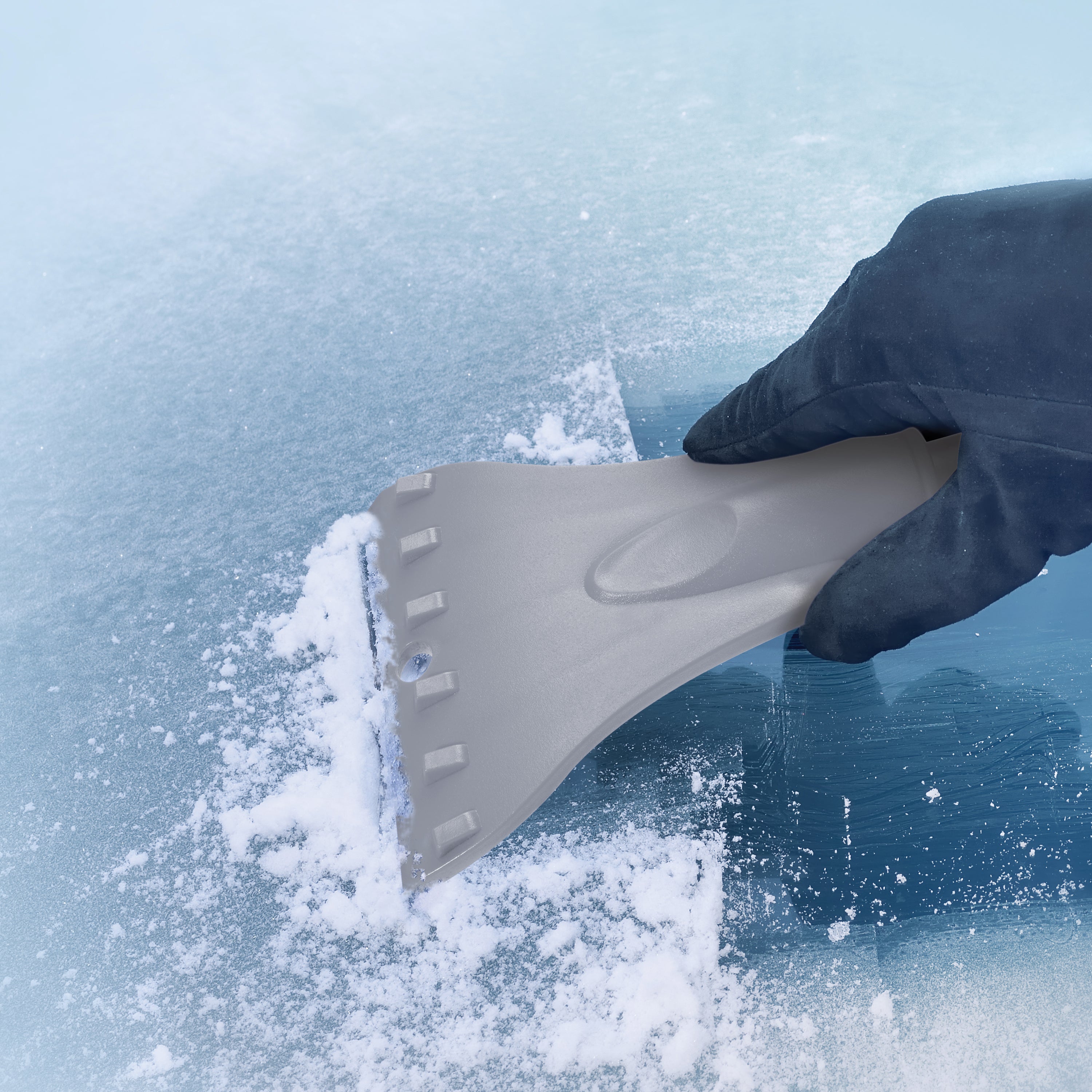 Snow Joe Telescoping gray Snow Broom and Ice Scraper being used to scrape ice off a window.