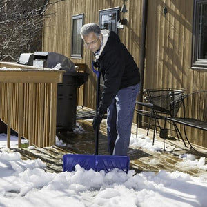 Snow Joe 24-inch 2-in-1 Snow Pusher and Ice Chopper being used to push snow off a patio deck.