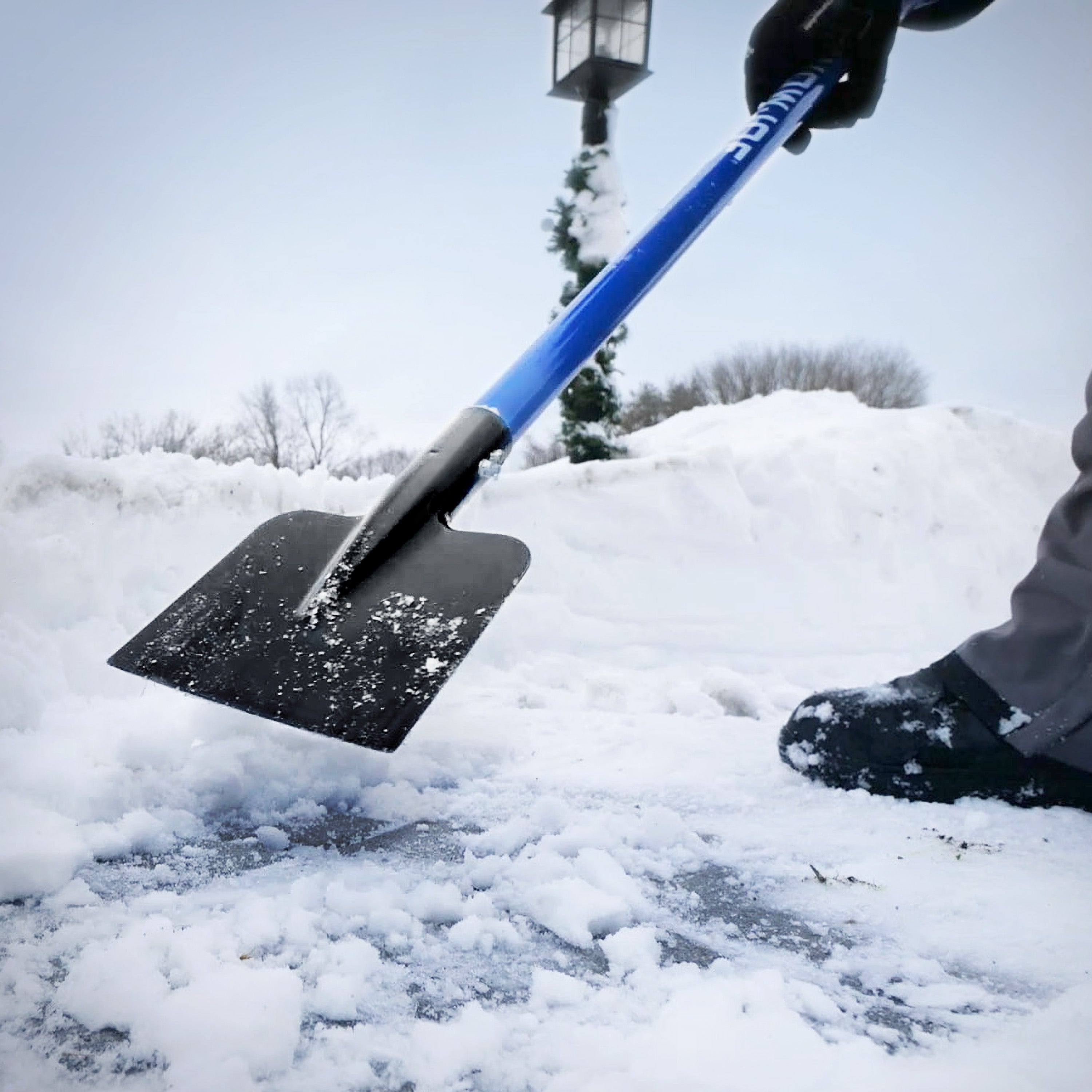 Person using the ice chopper to break ice on the ground.