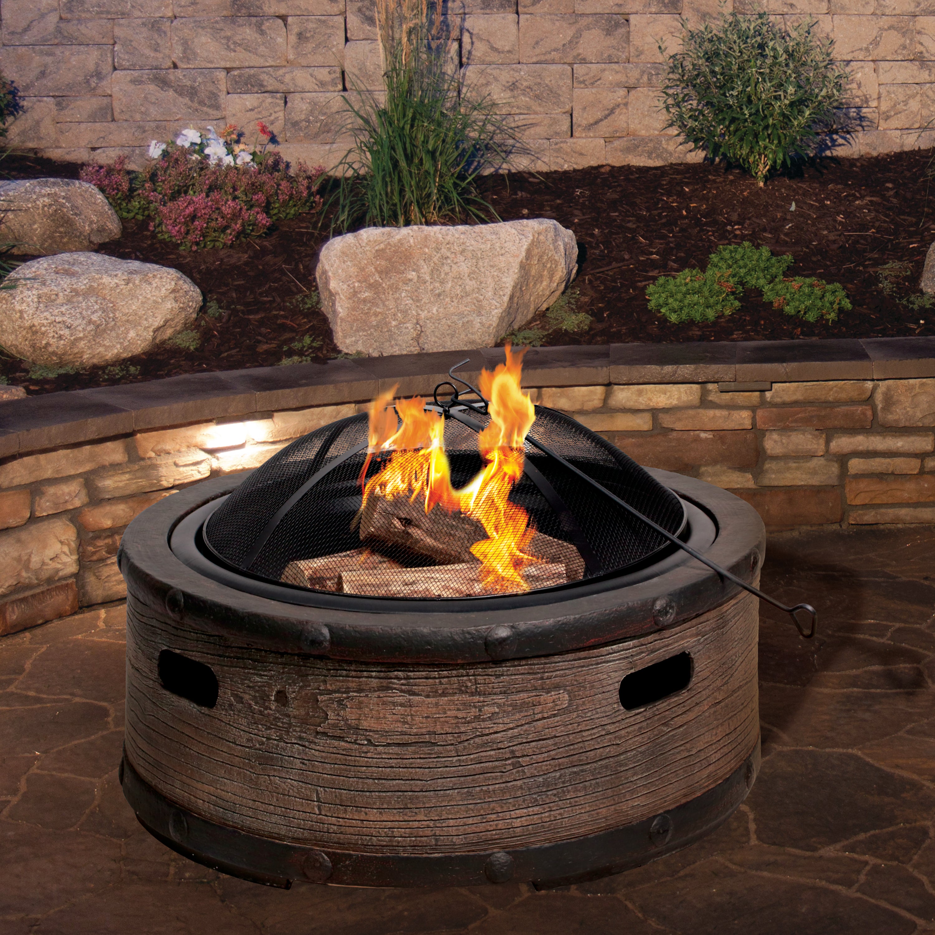 Fire going in the Sun Joe 35-inch Rustic Barrel Cast Stone Base, Wood Burning Fire Pit with the dome screen on top.