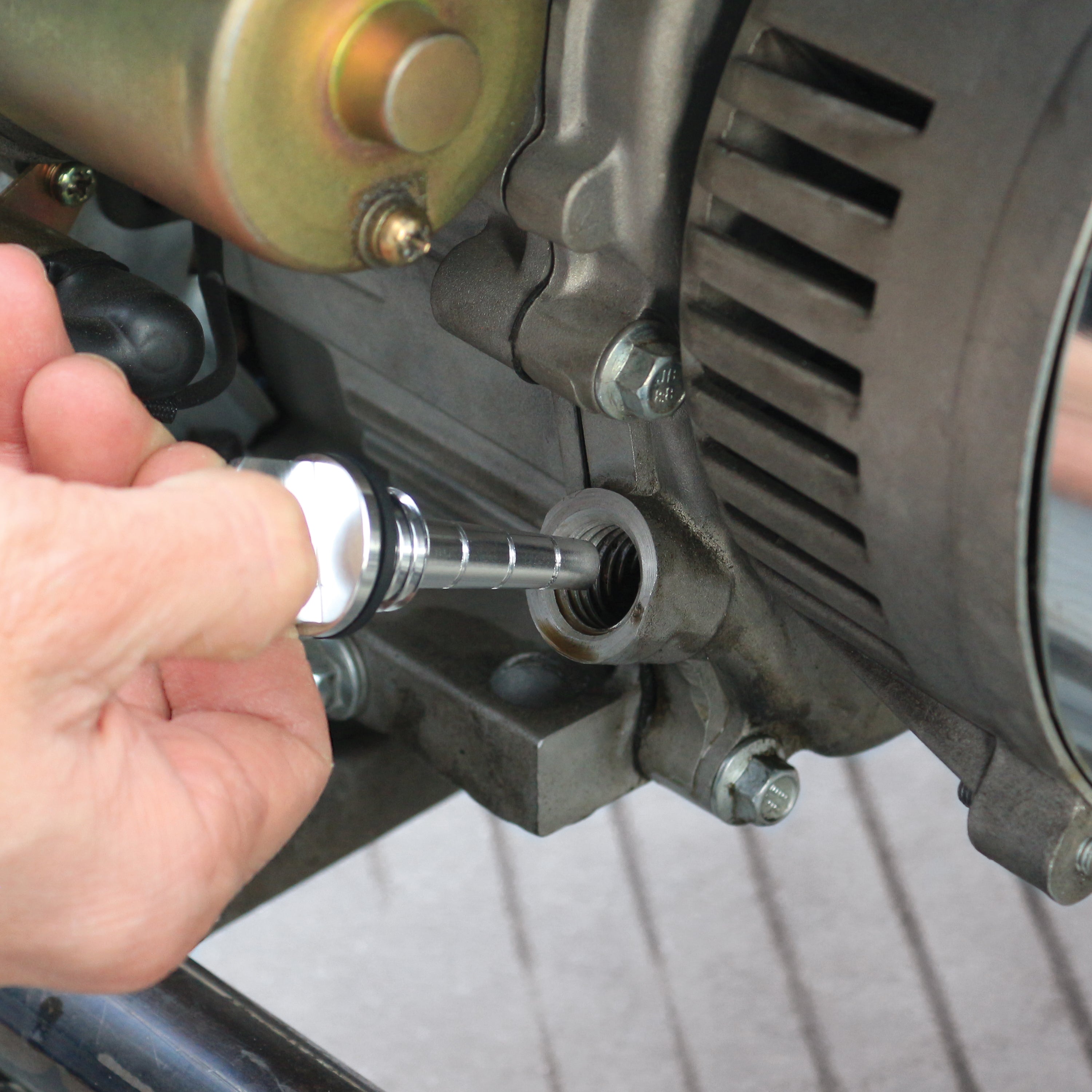 Person inserting the Sun Joe magnetic oil dipstick into a generator.