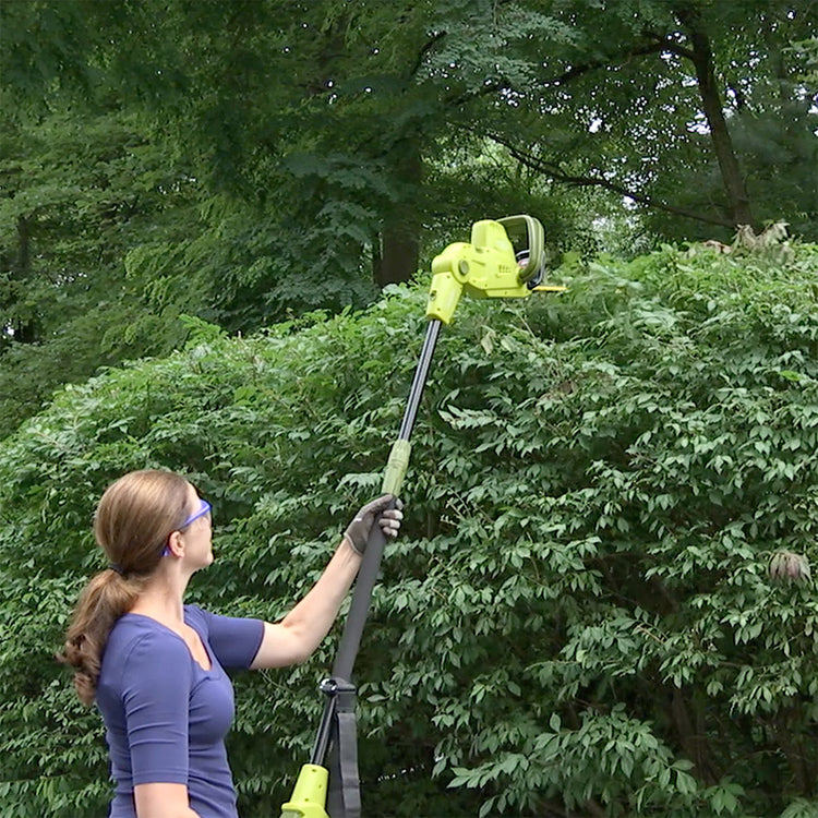 Sun Joe 4-amp 21-inch Electric Telescoping Pole Hedge Trimmer being used to trim a bush.