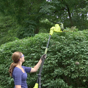 Sun Joe 4.5-amp 19-inch Multi-Angle Telescoping Convertible Electric Pole Hedge Trimmer being used to trim a large bush.