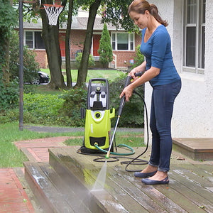 Sun Joe House and Deck All-Purpose Pressure Washer Rated Concentrated Cleaner being used to clean a patio deck with a pressure washer.