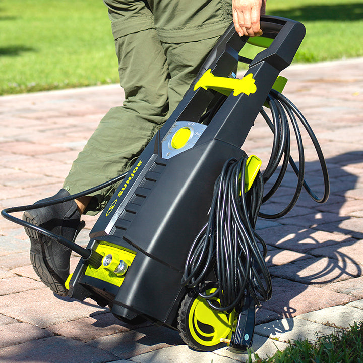 Sun Joe 13-amp 1950 PSI Electric Pressure Washer being wheel across a driveway.